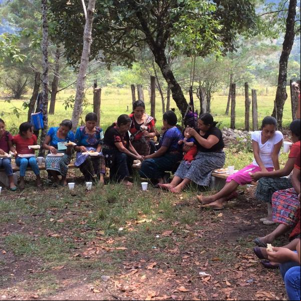 women community leaders of Ixquisis gather together beneath large trees. 